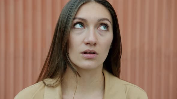 Slow Motion Closeup Portrait of Confused Young Woman Rolling Eyes Standing Outdoors