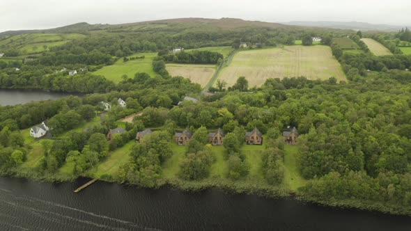 Fly in establishing shot of holiday rentals next to a beautiful lake in Ireland