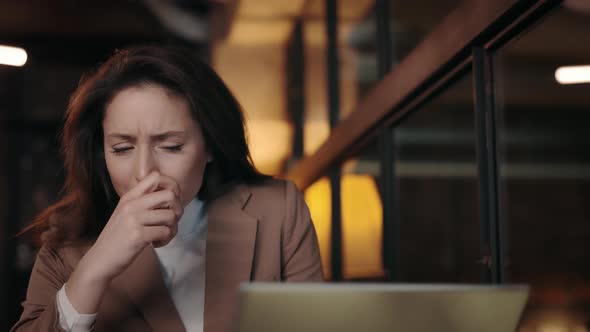 Sick Business Woman with Modern Laptop Coughing at Cozy Cafe