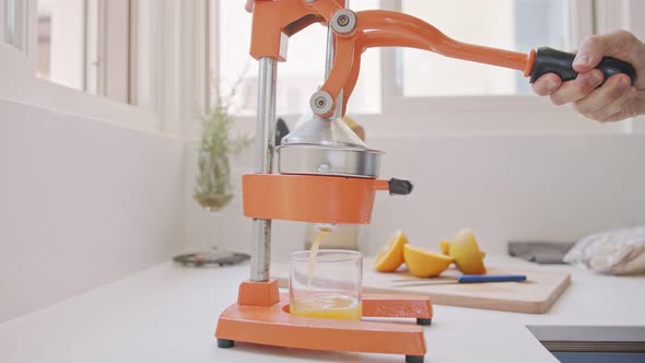 Super slow motion of fresh orange juice squeezed using a manual squeezer