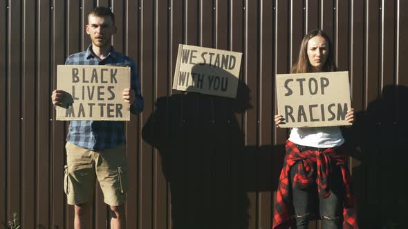 People with cardboard posters "Black Lives Matter" and "Stop Racism" in their hands. I can't breathe