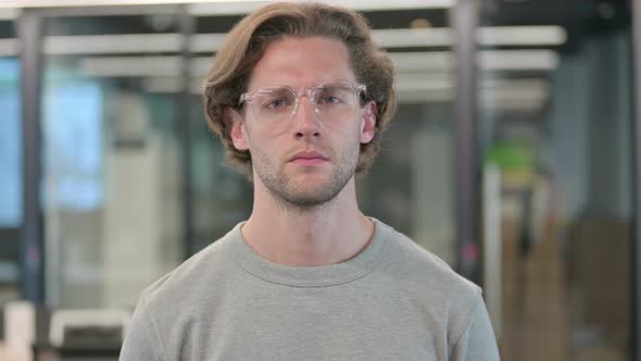 Portrait of Young Businessman Looking at Camera