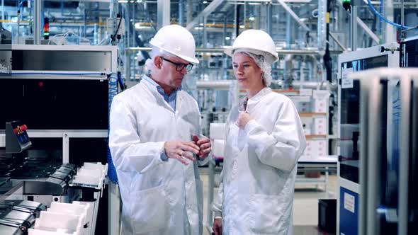 Employees in Lab Coats are Talking in the Solar Cell Factory Unit