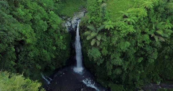 drone flight over the kedung kayang waterfall and the underlying water basin it creates in central j