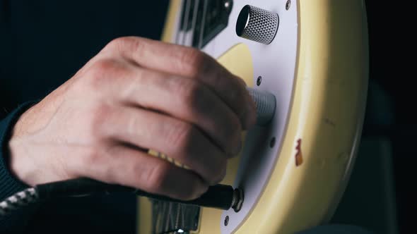 Bassist Connects Jack with Output and Rotates Control Knobs