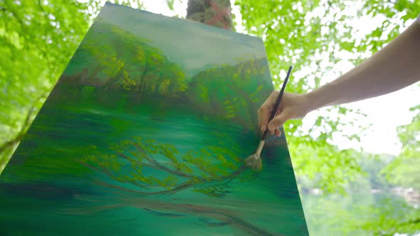 The painter paints in the forest.