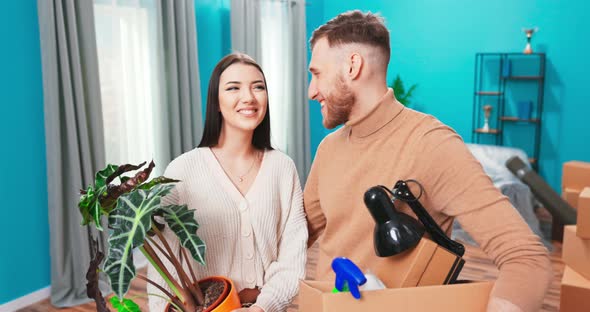 Portrait of Young Happy Couple Standing in the Middle of New Apartment