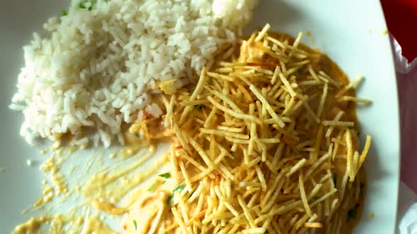 Overhead view of a rice dish being eaten with a fork