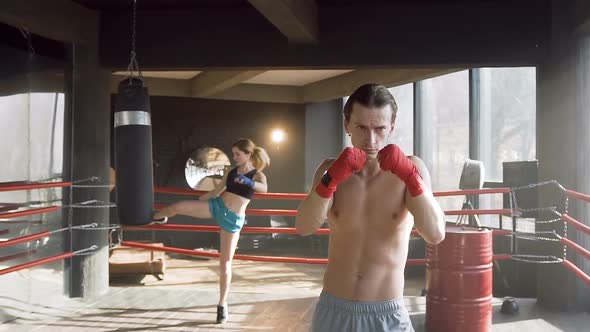 Caucasian Man and Woman Training in the Gym