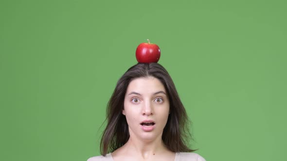 Close Up Shot of Young Beautiful Woman with Apple on Head