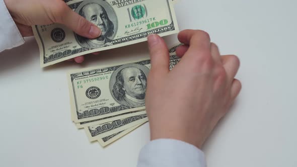 Counting Banknotes on a White Table