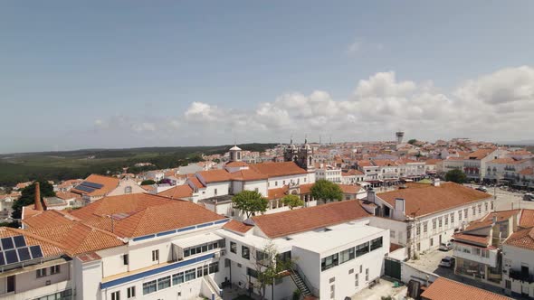Cinematic pan shot overlooking beautiful Nazare cityscape and famous church at central square.