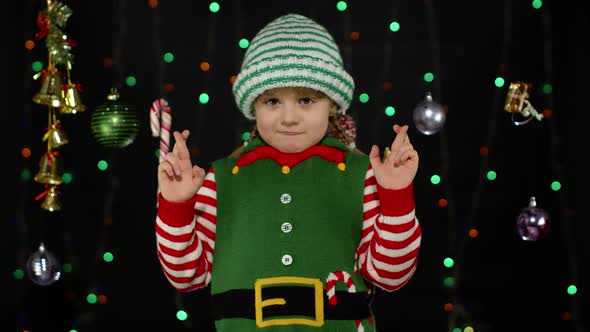 Christmas wish concept, Kid teen girl in Christmas elf Santa helper costume making a wish, prays