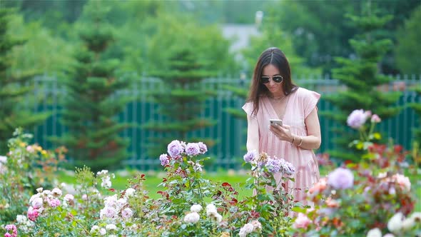 Young Girl in a Flower Garden Among Beautiful Roses, Smell of Roses