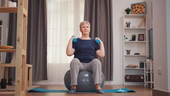 Old Retired Woman Lifting Dumbbells