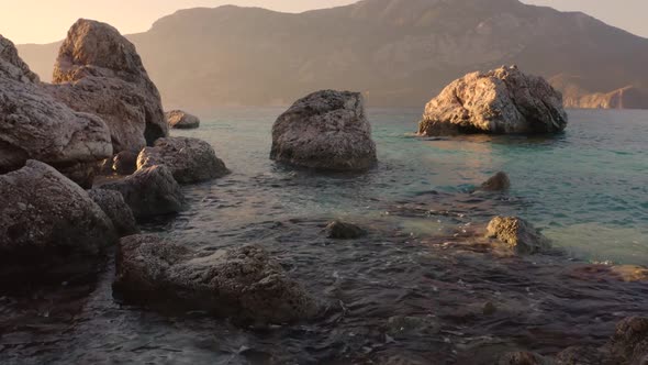 Rocky Beach with Turquoise Water and Mountains in the Background