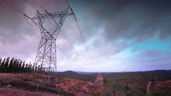 Stunning time lapse as colorful clouds sweep over electrical pylon, wide