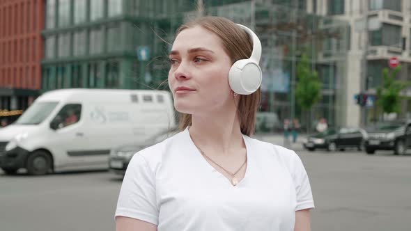 Closeup Face of Beautiful Smiling Woman with Long Hair on Headphones Enjoying Listening to Music