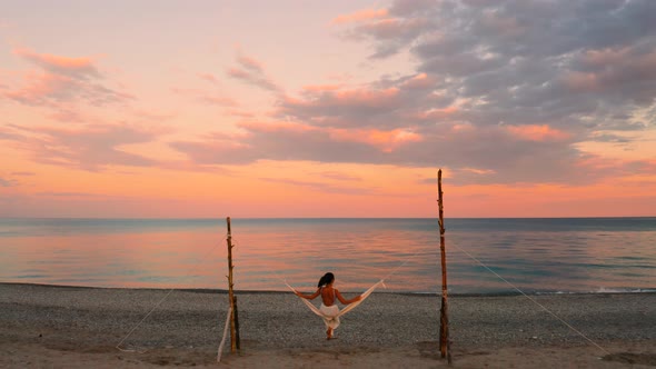 Girl on the Swing in front of the Ocean