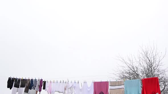 Clothes hanging on an outside washing line drying naturally under an overcast sky.