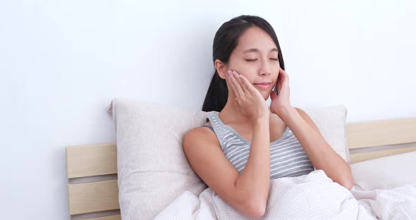 Woman Massaging on Her Face on Bed