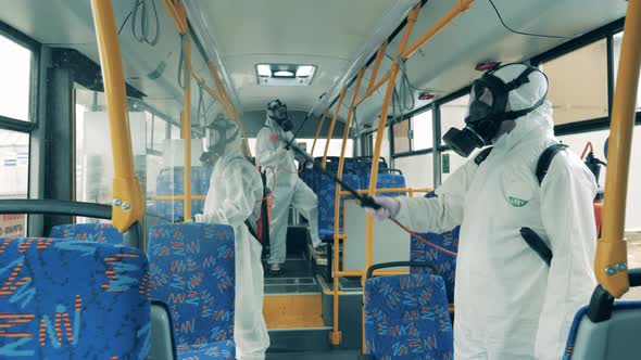 People in Protective Suits Kill Virus in a Bus During Disinfection