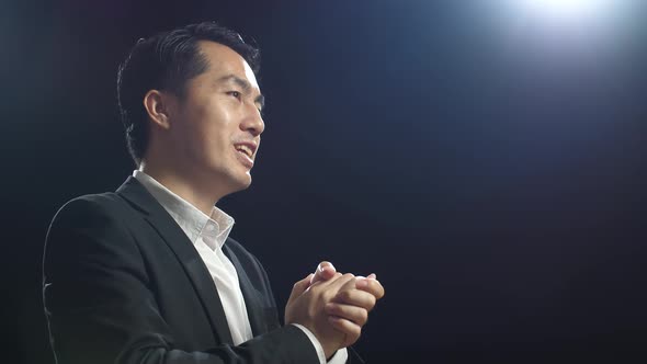 Close Up Side View Of Asian Speaker Man In Business Suit Showing Index Fingers Up While Speaking