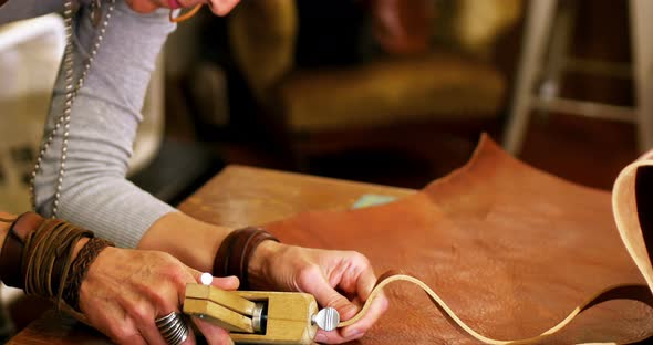 Close-up of craftswoman cutting leather