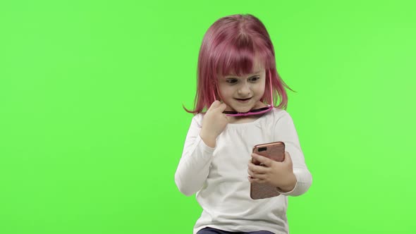 Girl Using Smartphone. Child Emotionally Talking on Mobile Phone, Take Selfie