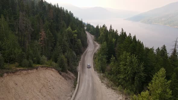 Silver van leaving for an adventurous drive through the vast pine forests of British Columbia. Aeria