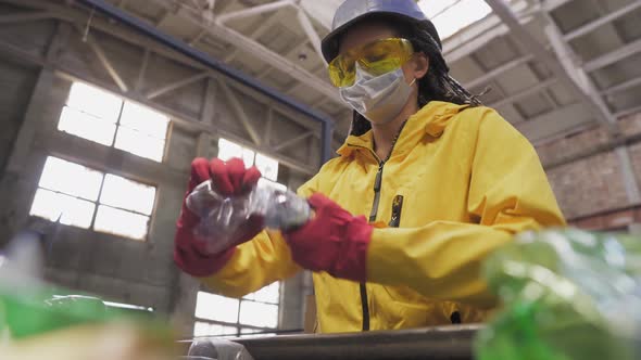 Womanvolunteer in Yellow and Transparent Protecting Glasses Hard Hat and Mask Sorting Used Plastic