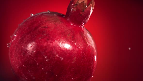 Super Slow Motion Water Drips on Rotating Pomegranate