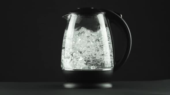 In a Electric Kettle with Transparent Glass Walls, Water Boils, Splashes.