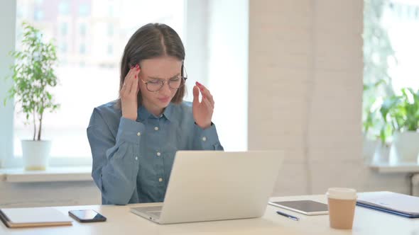 Young Woman Working on Laptop and having Headache