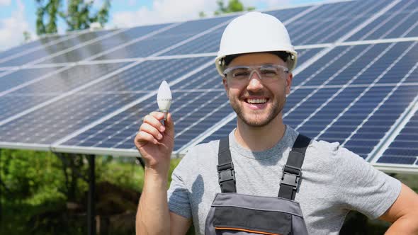 Engineer Standing with Lamp on Solar Panel and Feeling Freedom at View Point