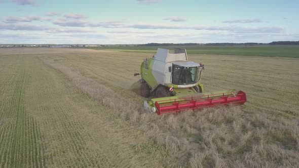 Close Side View Modern Combine Cuts Ripe Wheat on Field