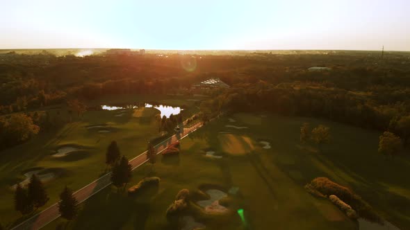 Flying Above Green Golf Field with Ponds