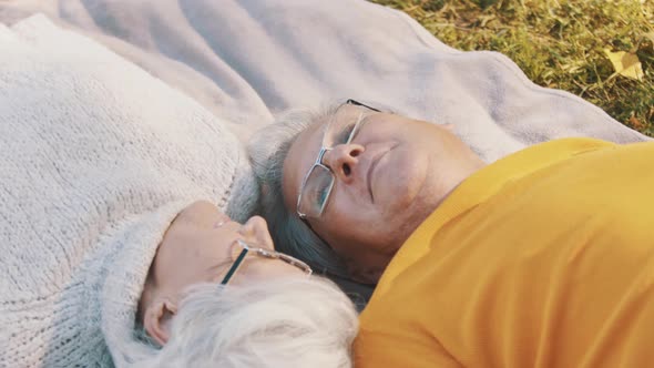 Romance at Old Age. Retired Couple Enjoying Autumn Picnick. Lying on the Blanket and Looking at Each