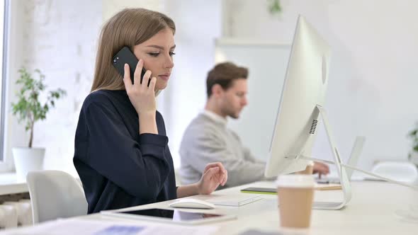 Happy Creative Woman Talking on Smart Phone in Office