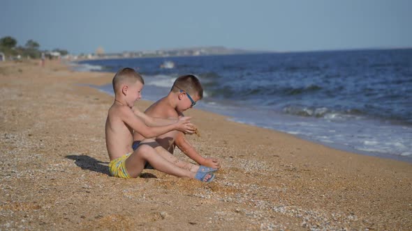 Rest on the Sea with Children. The Boys Throw Up a Shell with Sand. Children's Emotions. Boys Throw