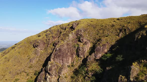 Drone approaching then flying over steep grassy cliff near Pelado peak in northern Costa Rica. Group