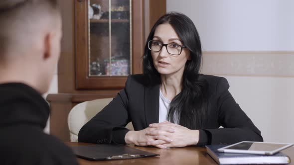 Portrait of Serious Professional Caucasian Woman Consulting Patient in Psychologist Office