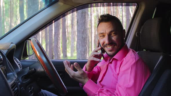 Happy Businessman Talking on the Phone While Driving and Smiling