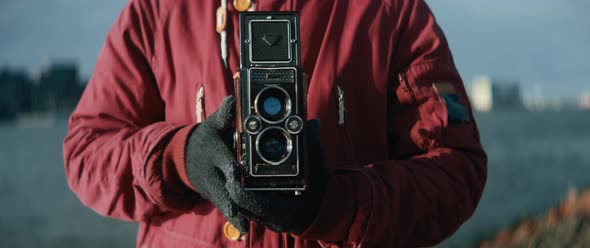 Close up of young man taking picture with vintage camera