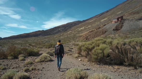 Tourist Man Walk Through the Mountains of Solidified Lava in the Teide Volcano National Park on the