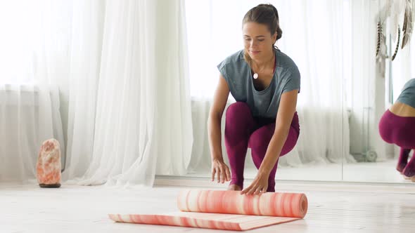 Woman Rolling Up Mat at Yoga Studio or Gym 20