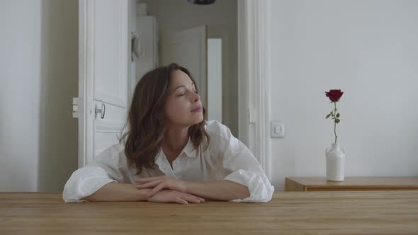 Attractive girl waking up at a table in apartment