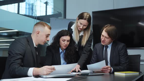 Female Business Leader Writing on Paper at Meeting in Office