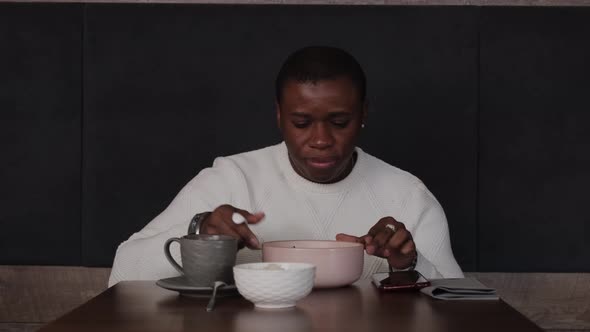 African American Man Having Breakfast in Asian Cafe