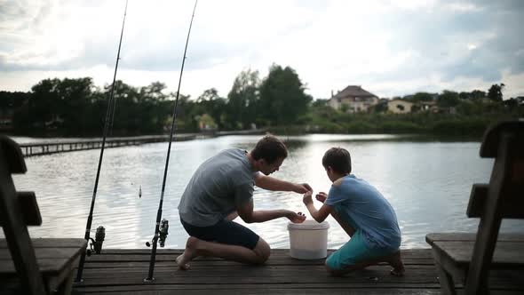 Carefree Dad and Son Preparing To Fish on the Lake